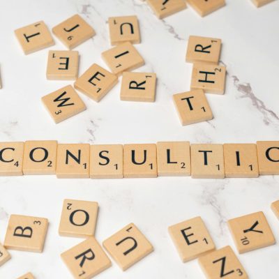 Scrabble tiles spelling 'Consulting' on a stylish marble surface symbolize strategic creativity.